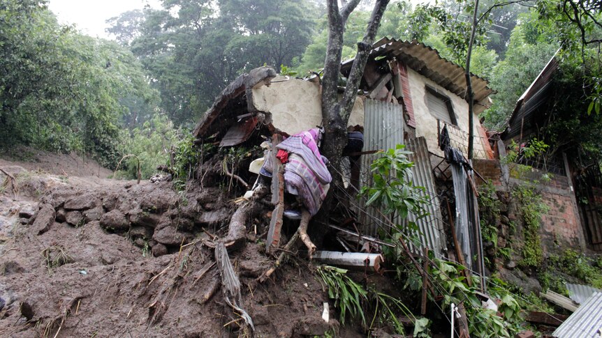 A 100m hillside came down on five houses in El Salvador, killing at least nine people