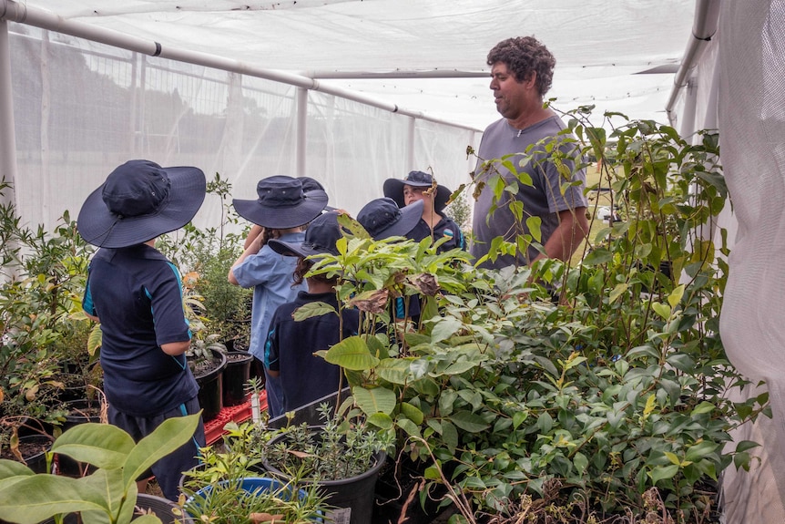 A man talking to students in a nursery