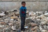 Child stands in rubble in Aleppo