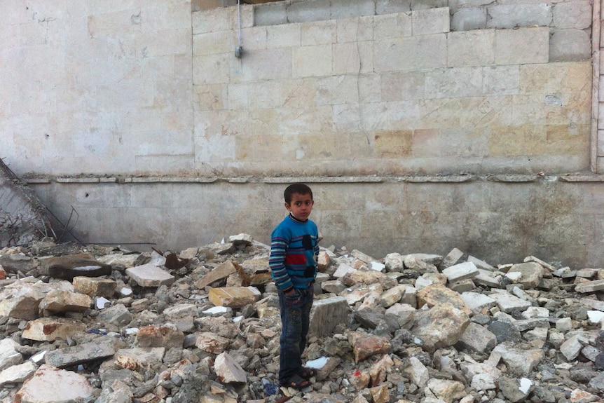 Child stands in rubble in Aleppo