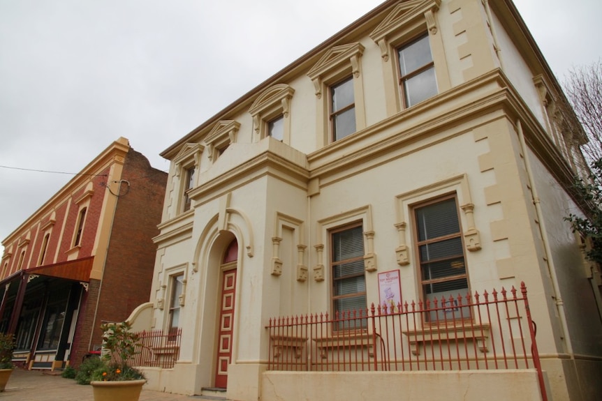 An exterior shot of a grand, historical building with an arched entrance.