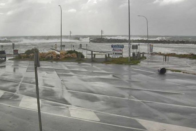 Waves wash across a car park on the sea front