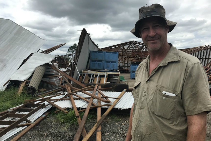 Scott Dorman standing in front of his shattered packing shed.