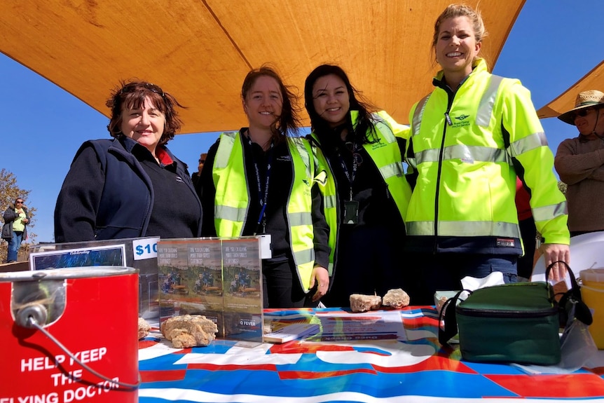 RFDS staff smile behind a fundraising stall.