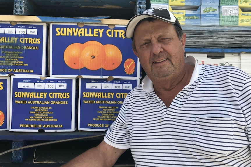 Alwyn Weier poses in front of fruit boxes in his truck.