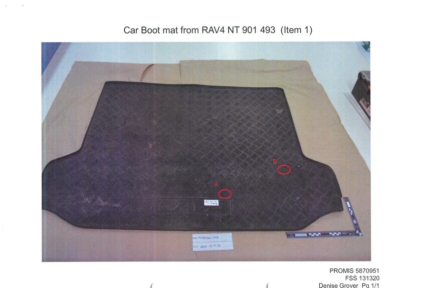 A rubber car boot mat with two areas of alleged blood circled.