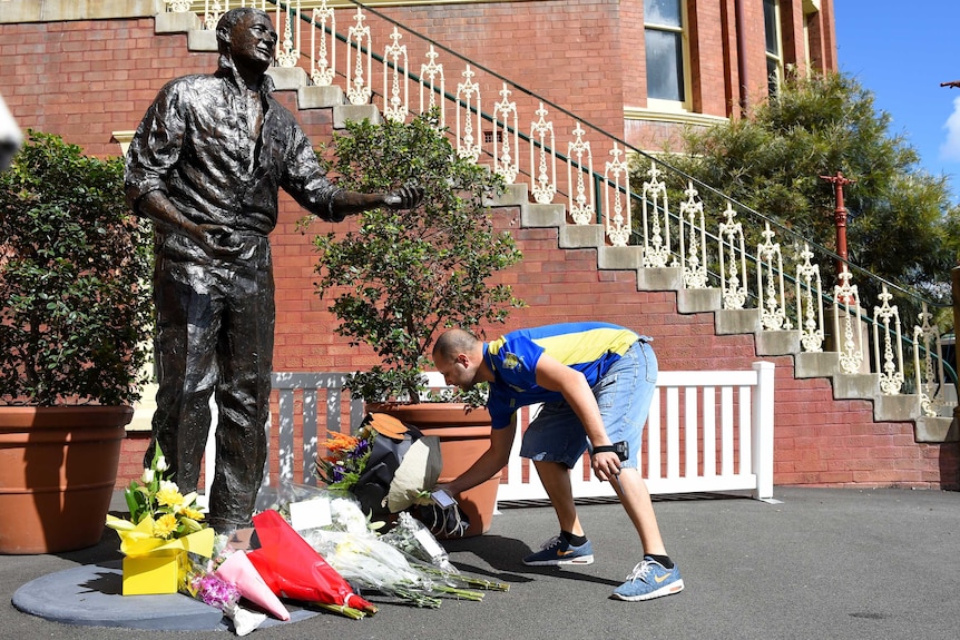 Flowers laid at the base of Richie Benaud's statue at the SCG
