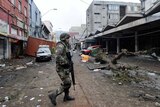 A soldier patrols the debris-covered downtown Talcahuano, Chile