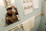 Yuliia Paievska, known as Taira, looks in the mirror and turns off her camera in Mariupol, Ukraine on February 27, 2022.