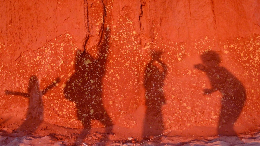 Shadows of children on a red cliff