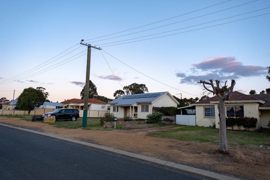 A row of simple one-storey houses including one with rooftop solar