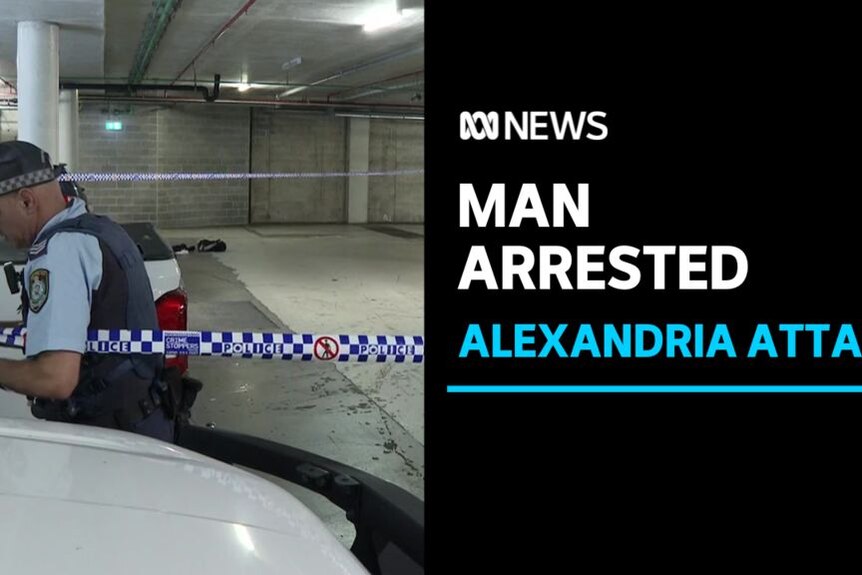 A police officer sets up police tape in an underground carpark.