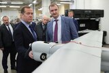 Dmitry Medvedev (left) examines a drone.