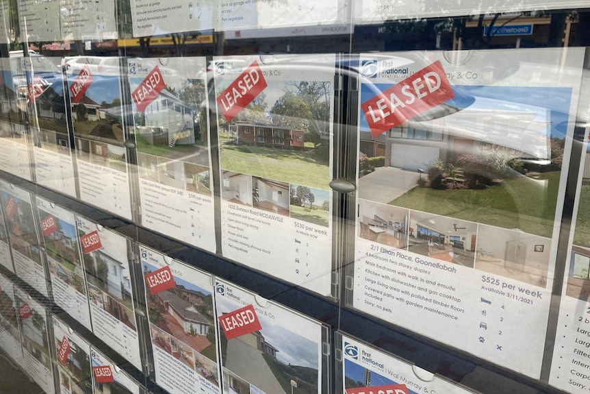 A real estate agency window showing rental properties that have been leased.