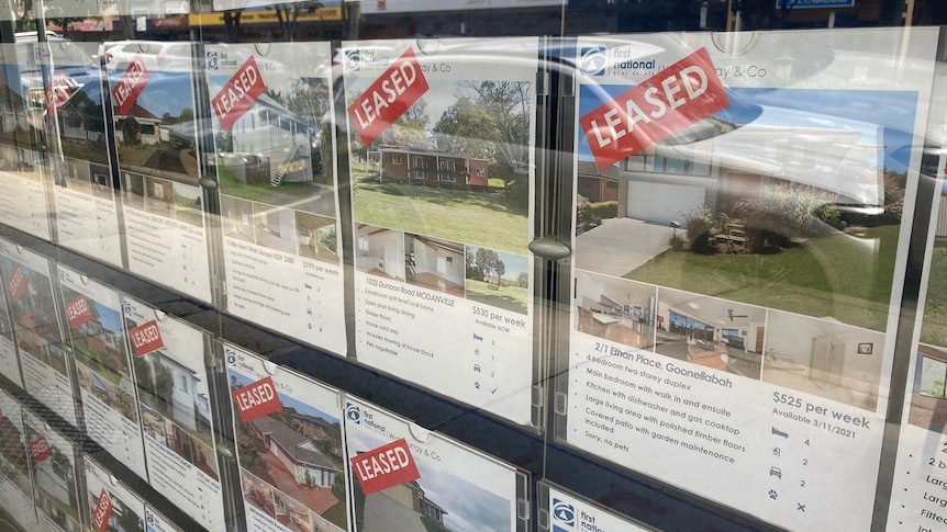 A real estate agency window showing rental properties that have been leased.