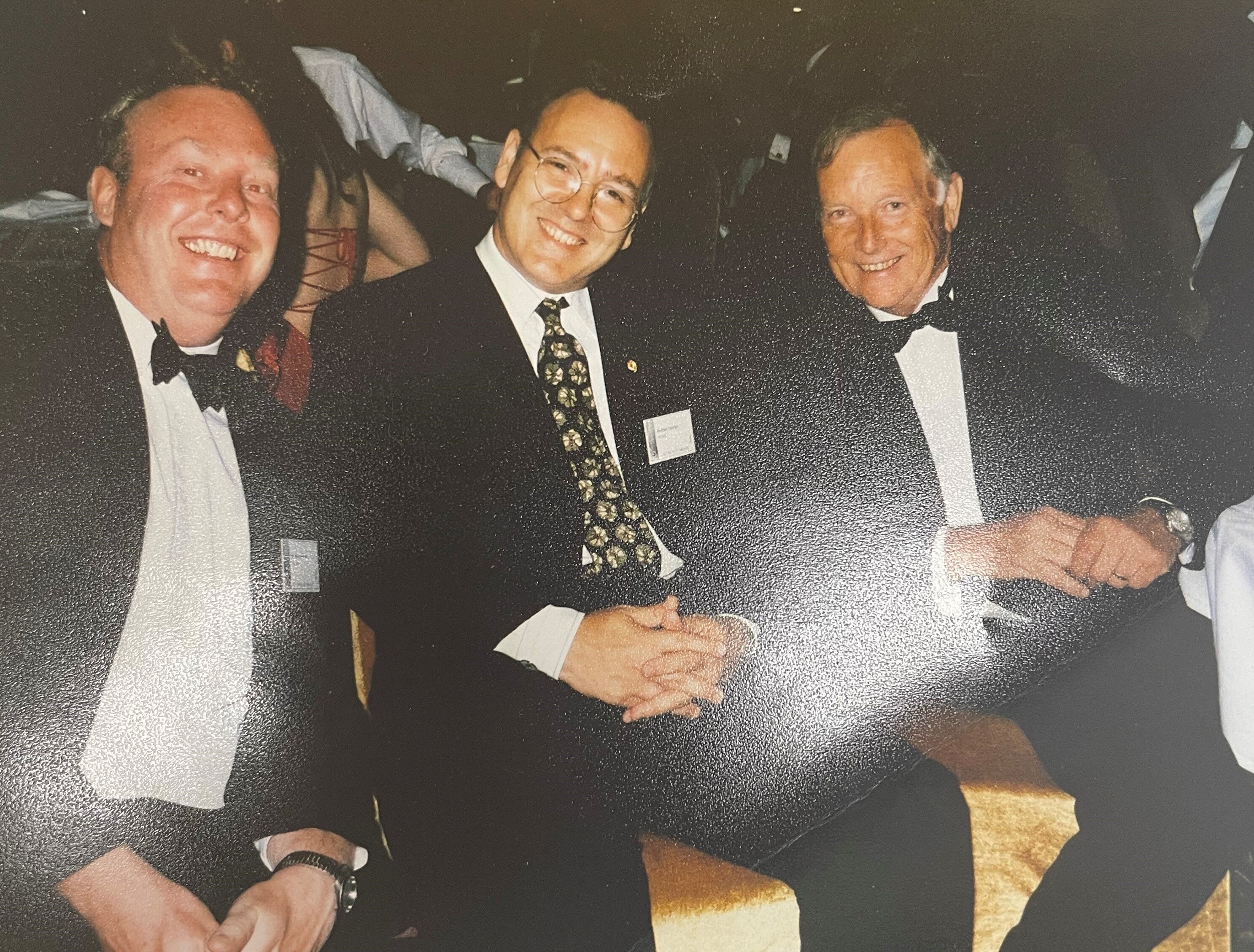 three men smile at camera 