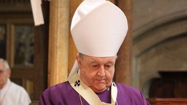 Archbishop Philip Wilson holds communion wine.