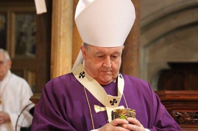 Archbishop Philip Wilson holds communion wine.