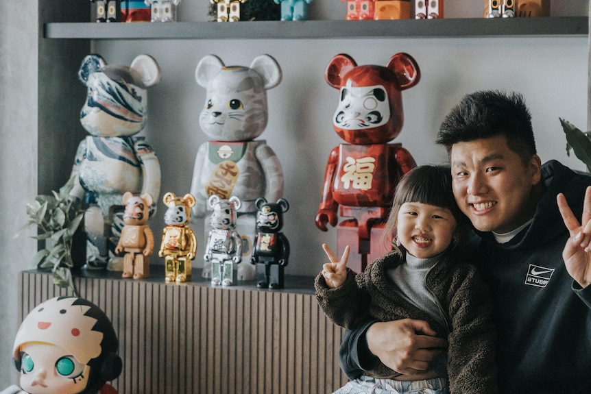 Silas Chau poses for a photo with his Bearbrick collection and daughter.