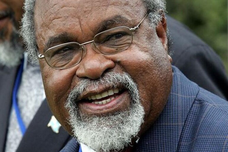 Papua New Guinean Prime Minister Michael Somare; a man with a white beard, smiling, wearing a dark blue suit.