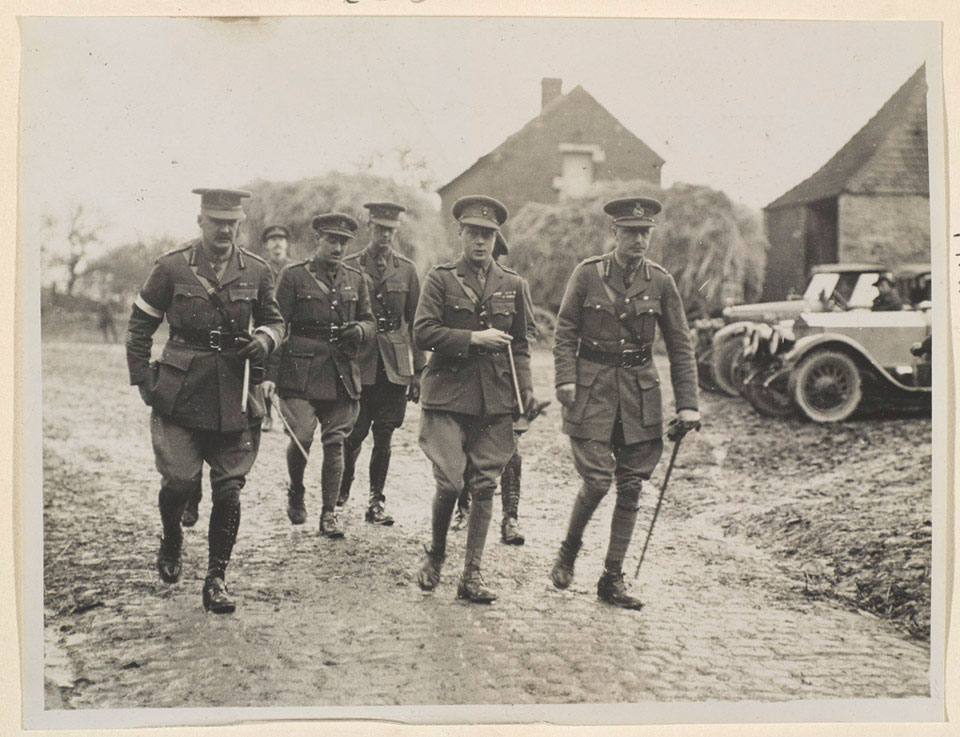 Homens uniformizados caminham por uma cidade em busca de uma coluna