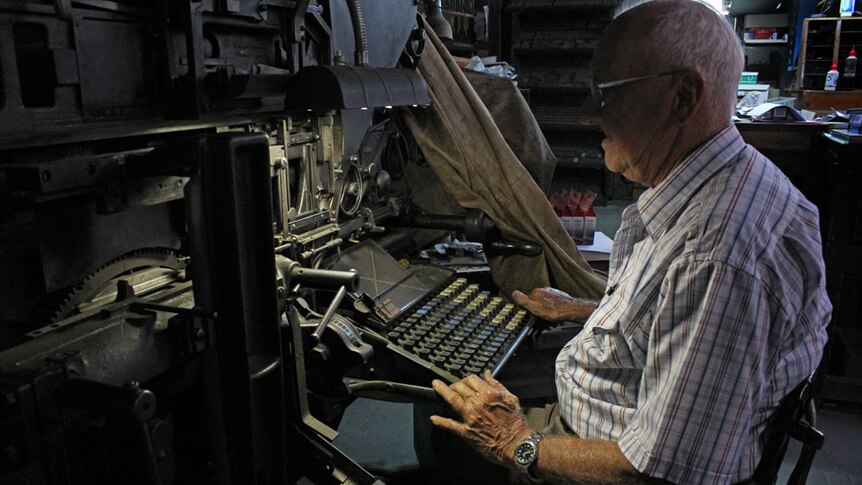 Mature-aged man sitting behind a linotype machine.