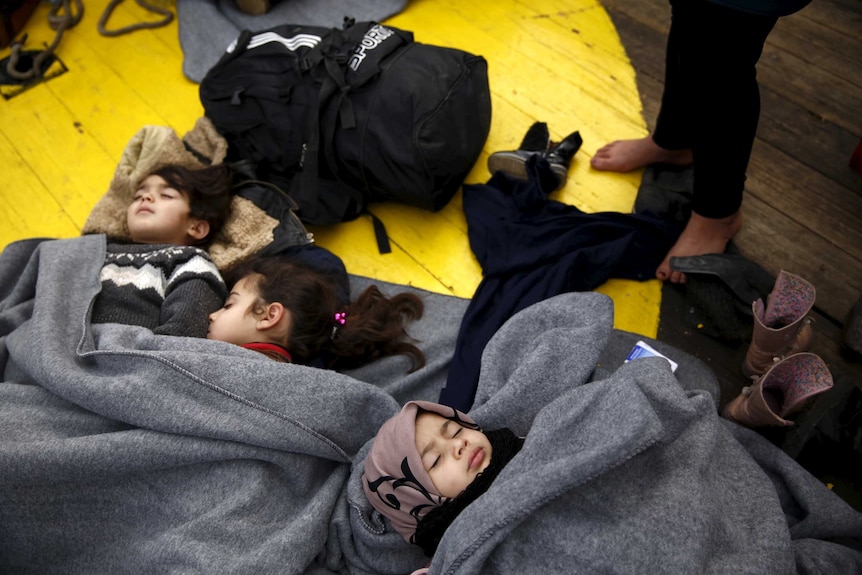 Children sleep on the deck of a Greek rescue ship