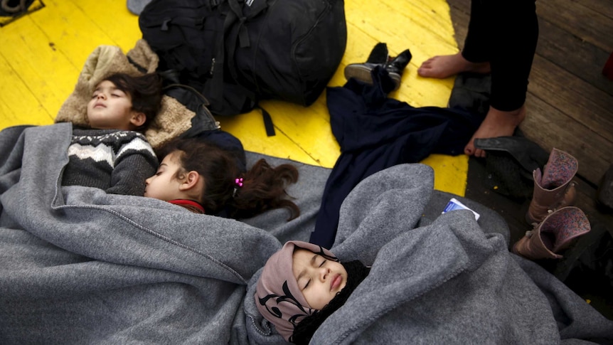 Children sleep on the deck of a Greek rescue ship