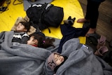 Children sleep on the deck of a Greek rescue ship