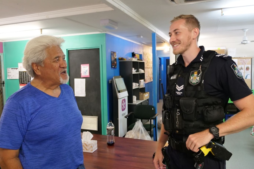 Maori man with white hair chats to police officer