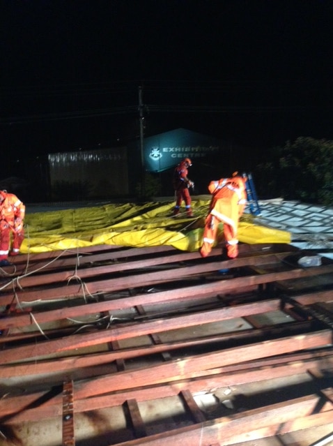 SES volunteers pull tarps on a motel that lost its roof in Stanthorpe on Qld's Granite Belt on November 11, 2013.