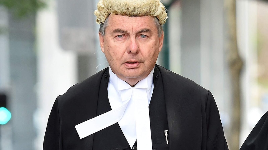 Walter Sofronoff dressed in court robes walks down a street. in Brisbane