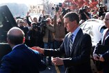 Michael Flynn is photographed by paparazzi and confronted by a protester with a sign reading "Lock him up"