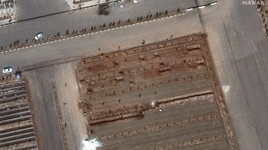 A satellite image shows a mass buriul site and a parge pile of white lime