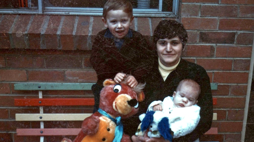 A grainy photo of Maria James, sitting next to her young son and holding a sleeping baby in her arms.