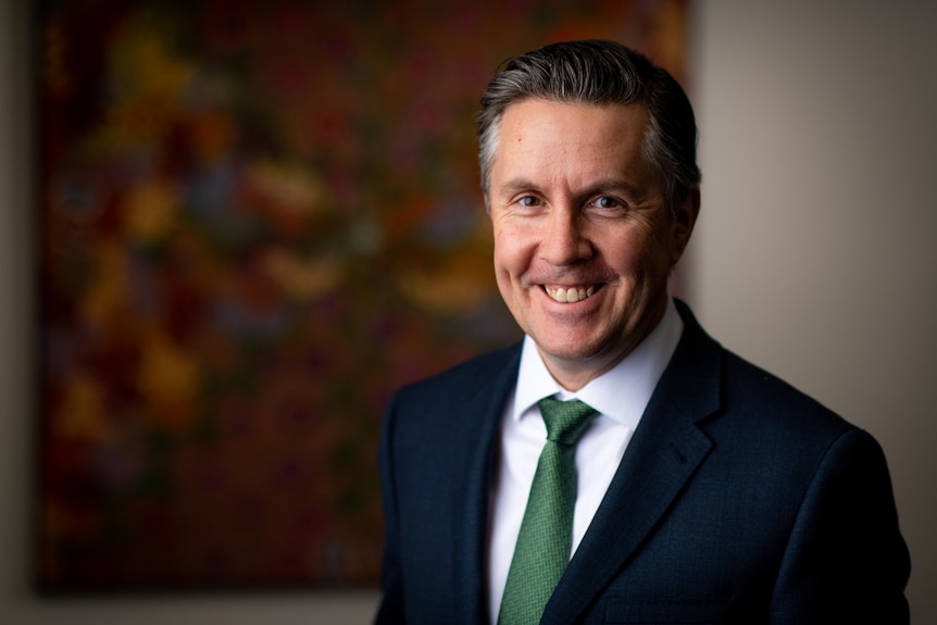 A man wearing a suit and tie while smiling