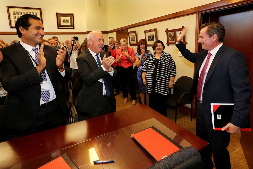 Mark McGowan waving as he enters a room of clapping colleagues