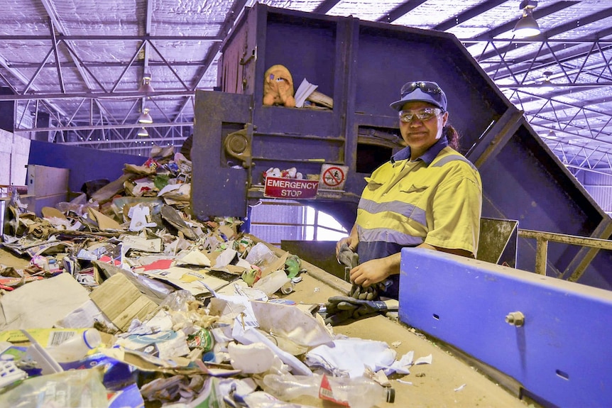 Worker at Hume recycling plant checking for contaminates