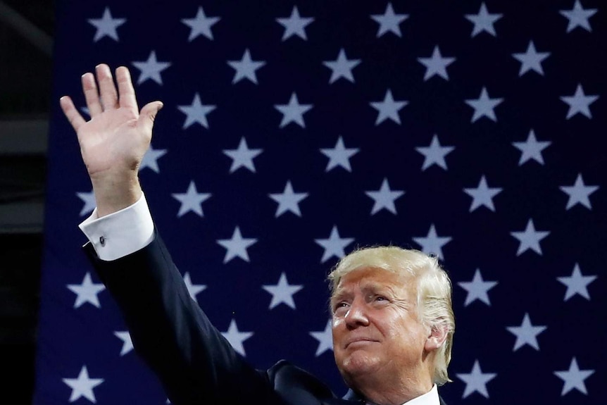 US President Donald Trump with Stars and Stripes in the background.