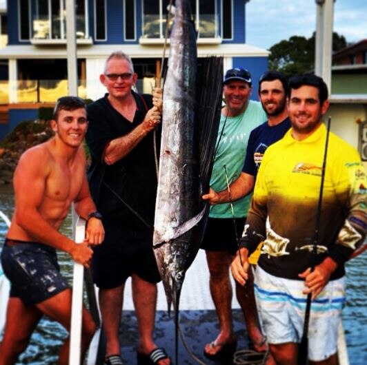 A group of men catching a large fish