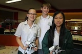 High school students stand with the Lego robot creations.