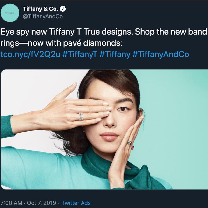 A screen shot of a Tiffany & Co advertisement of a woman with her hand over her eye.