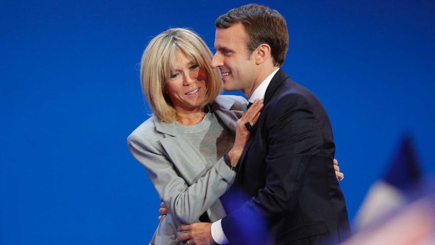 French president-elect Emmanuel Macron and his wife Brigitte hug as he addresses supporters in Paris.