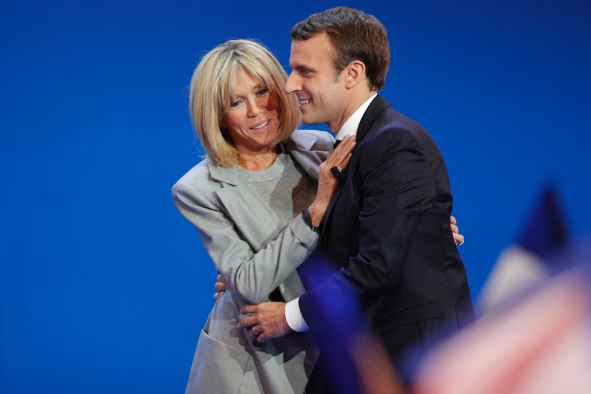 French president-elect Emmanuel Macron and his wife Brigitte hug as he addresses supporters in Paris.