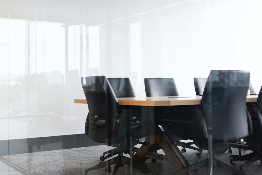 Office chairs around a table in an empty meeting room.