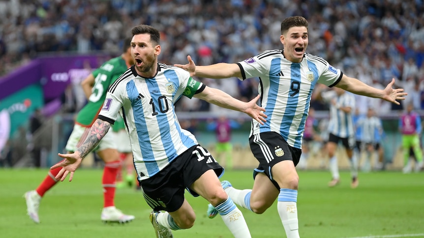 Lionel Messi holds his arms aloft alongside a celebrating teammate after scoring for Argentina