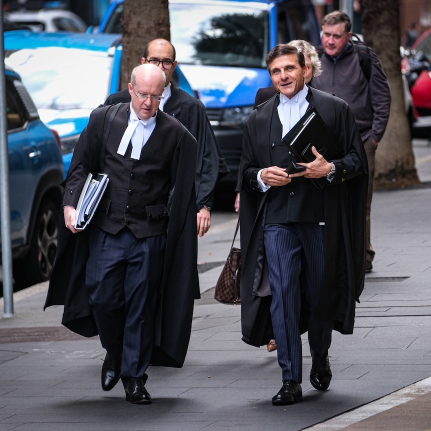 Two men in legal regalia walking side by side 