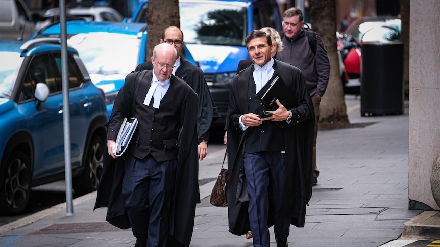 Two men in legal regalia walking side by side 