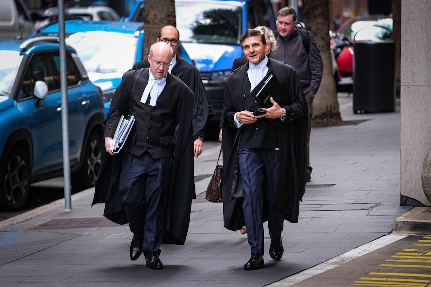 Two men in legal regalia walking side by side 