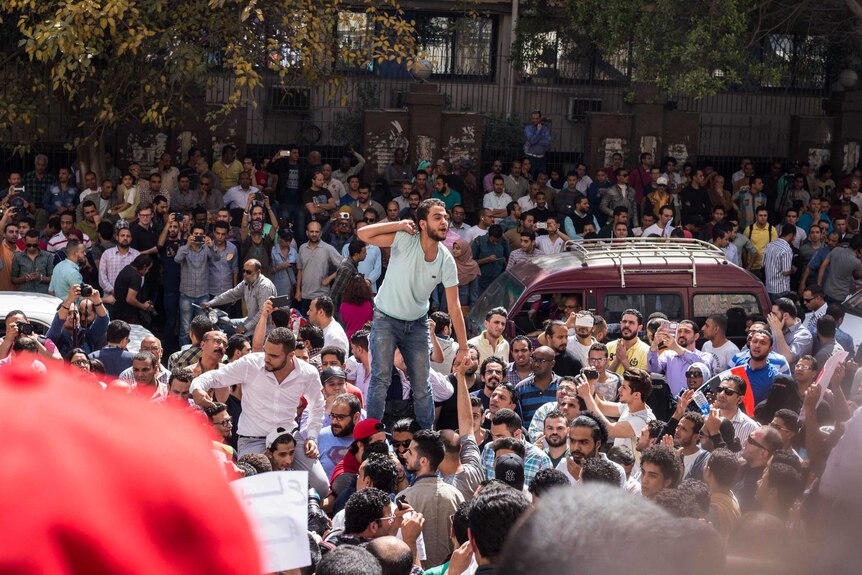 A man is lifted above the crowd in central Cairo during protests